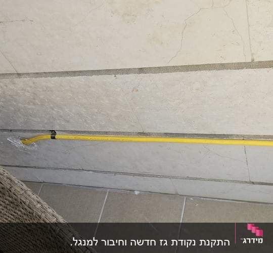 צינור גז צהוב מותקן על קיר מרוצף